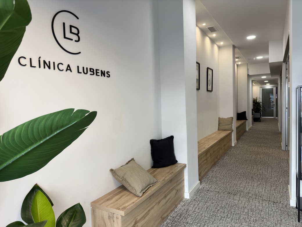 Pasillo de acceso a las consultas de Clínica Lubens, con el logo de la clínica en la pared