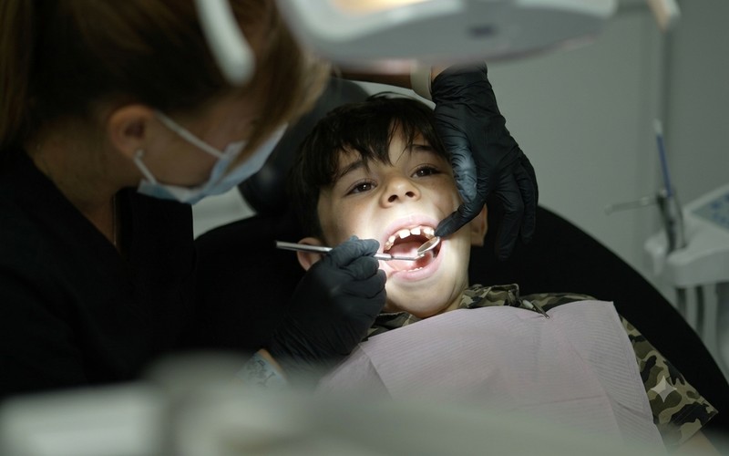 Odontóloga revisando la dentadura de un niño en Clínica Lubens